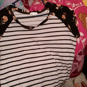 A black and white shirt with flowers on the sleeves